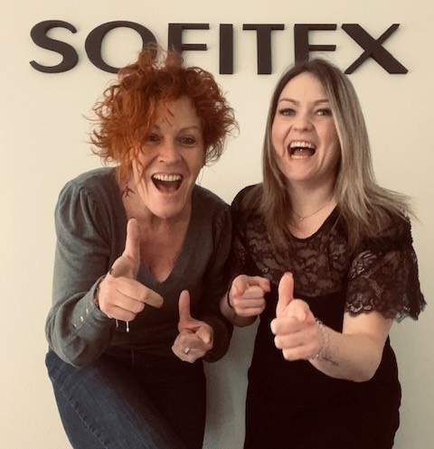 Deux collaboratrices souriantes devant le logo Sofitex