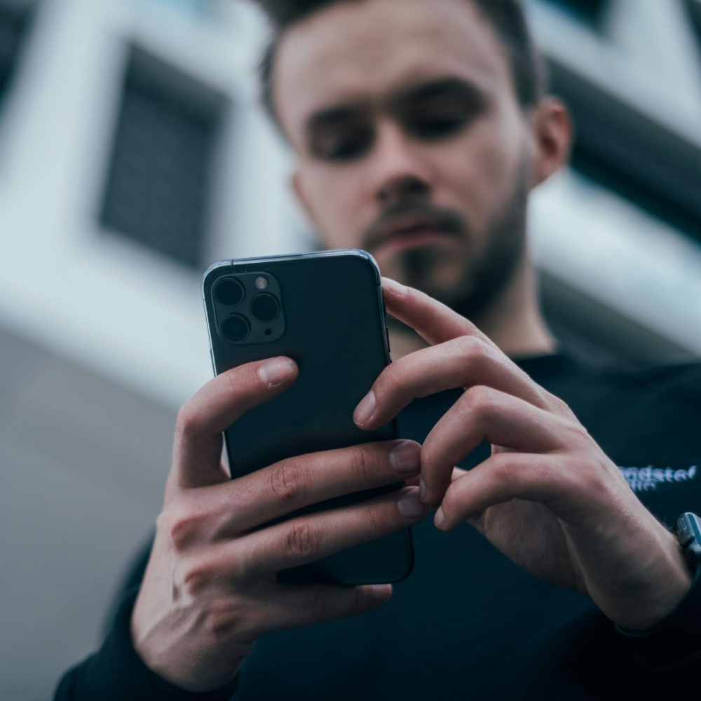 Homme consultant son smartphone en extérieur